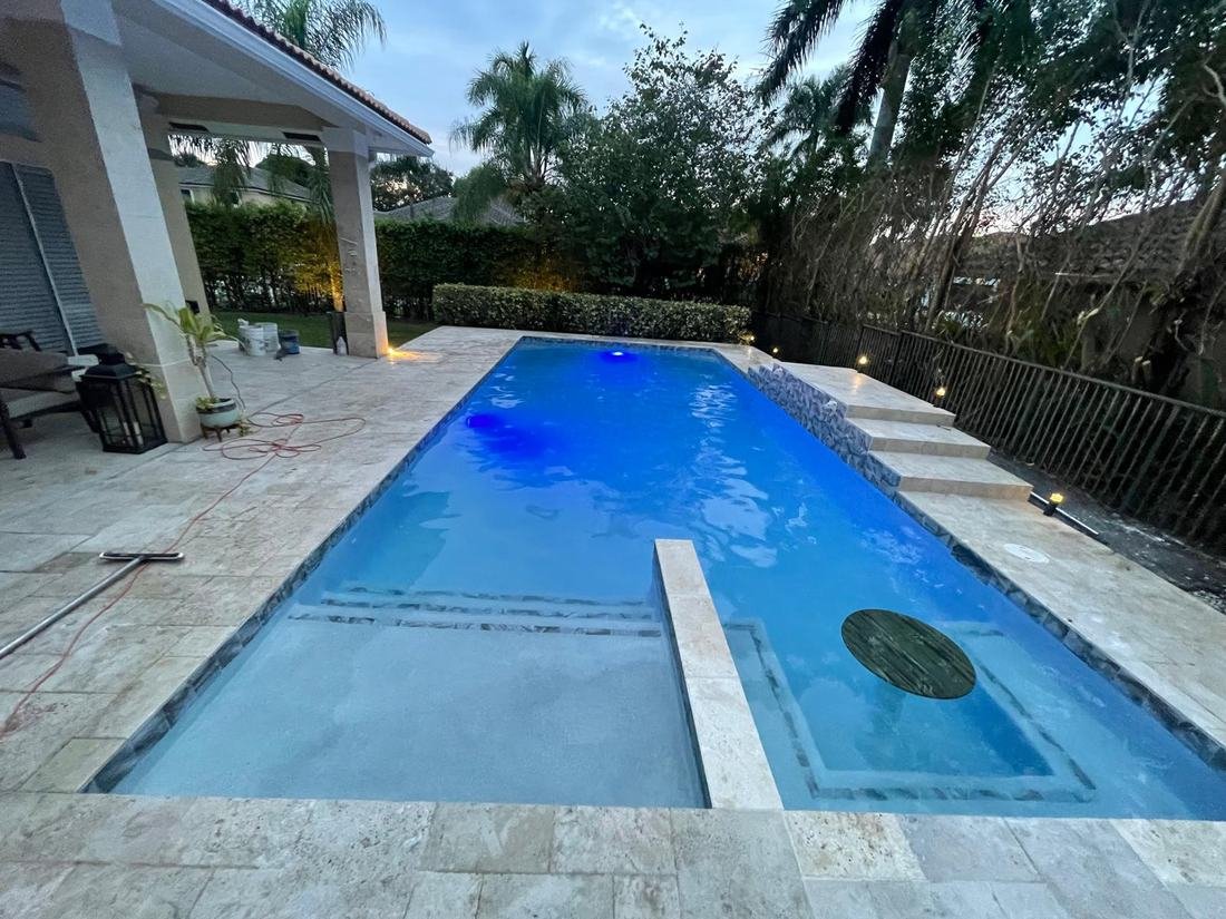 Finished pool at dusk with blue lighting, second angle