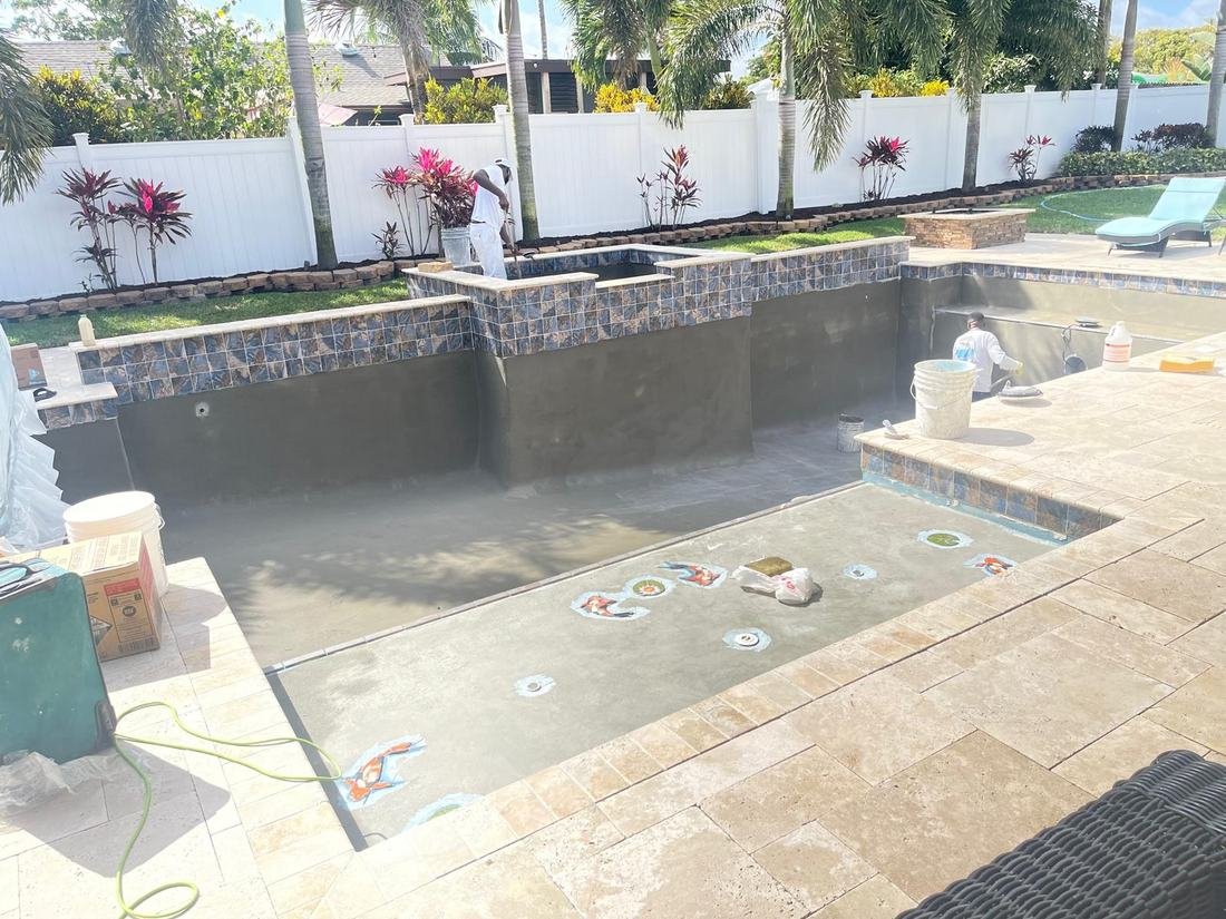 Pool mid-plaster with custom koi fish design taking shape