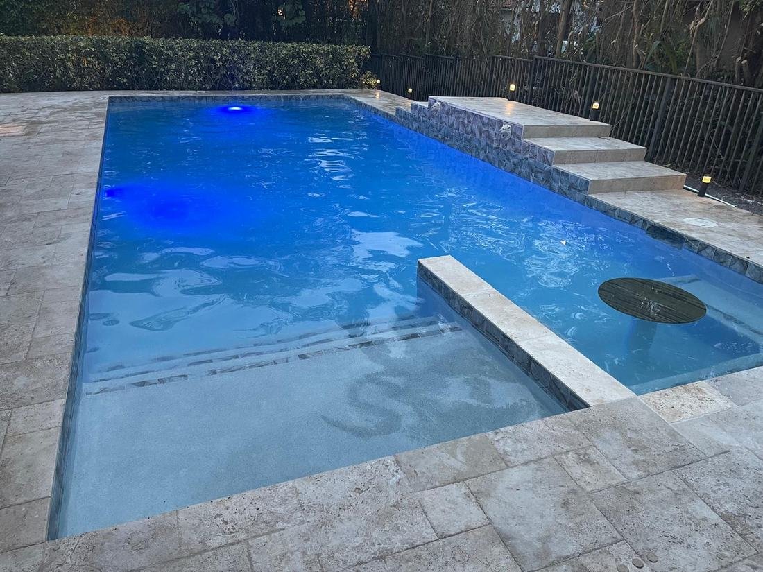 Finished pool filled with blue water and LED lighting at dusk